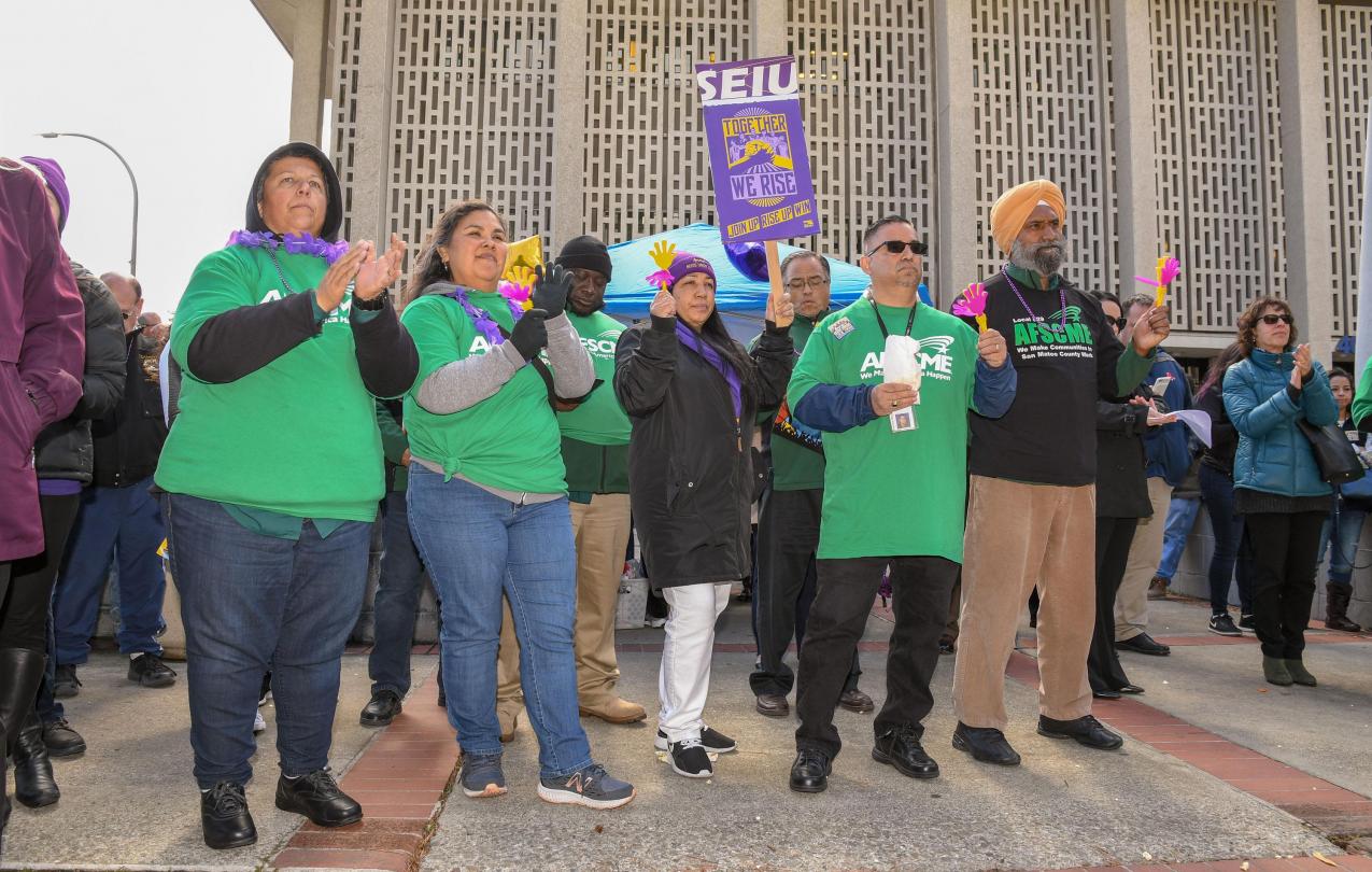 AFSCME Local 829 members and SEIU members listen to speakers at the Together We Rise rally in San Mateo County.