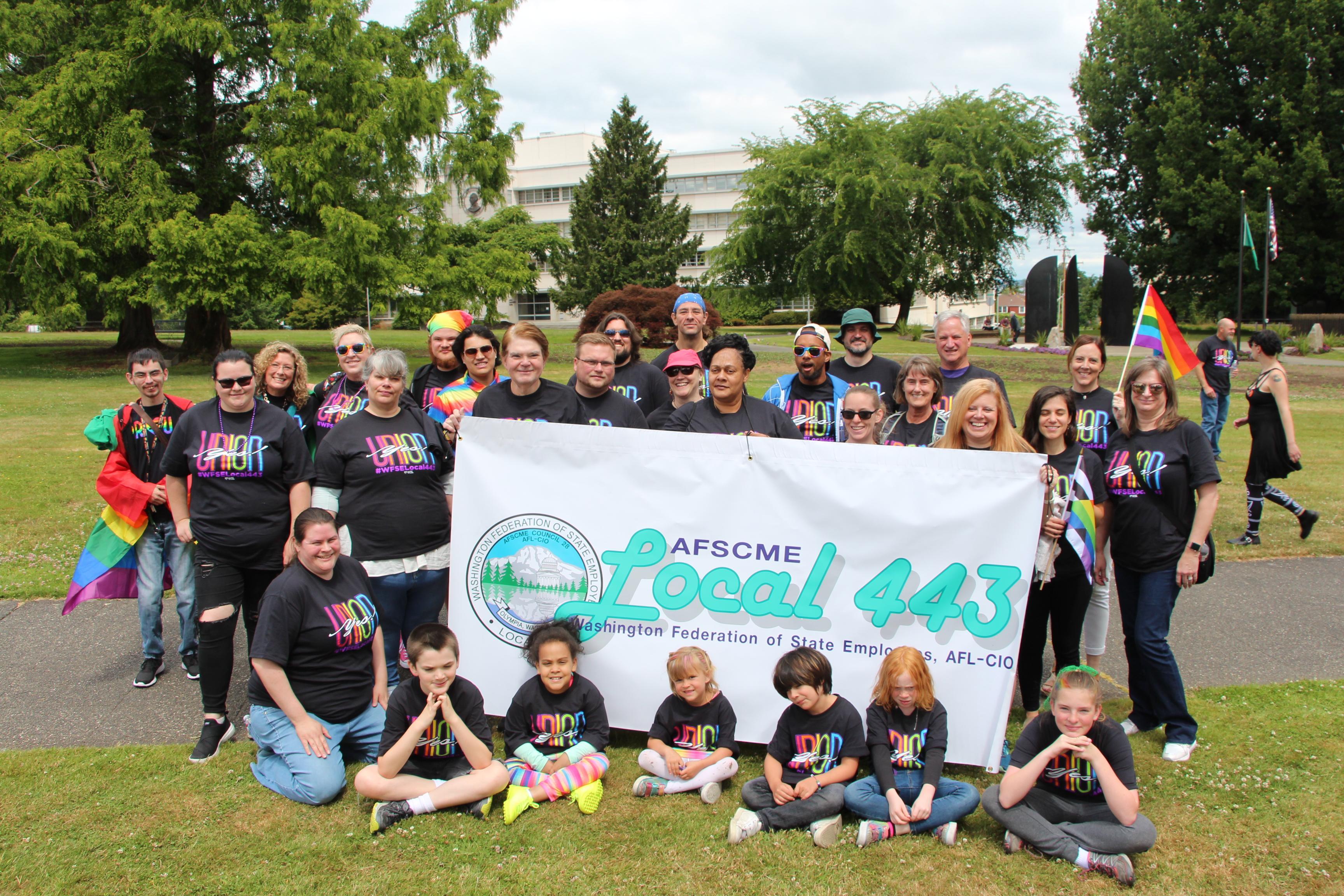 WFSE Local 443 members and their families hold a banner and pose during the Olympia Pride parade.