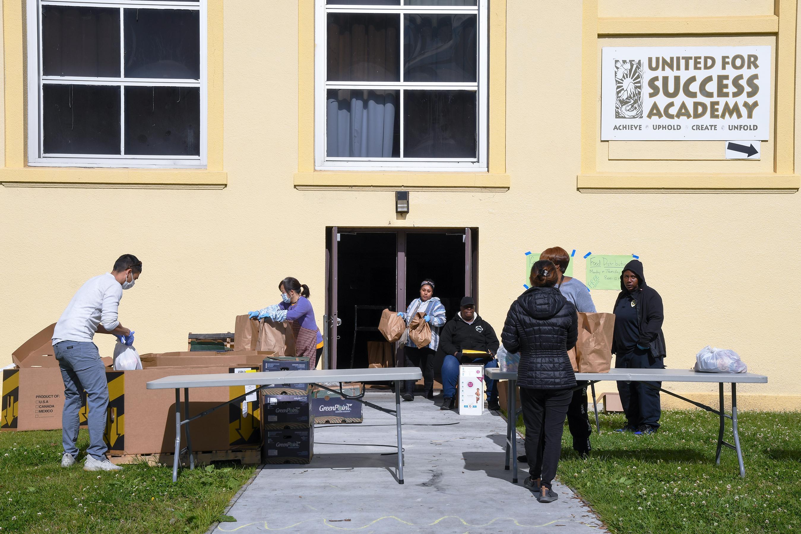 Katheryine Posey (center, seated), a Local 257 member and cafeteria manager, makes sure meals are being handed out safely and promptly at United for Success Academy in Oakland.