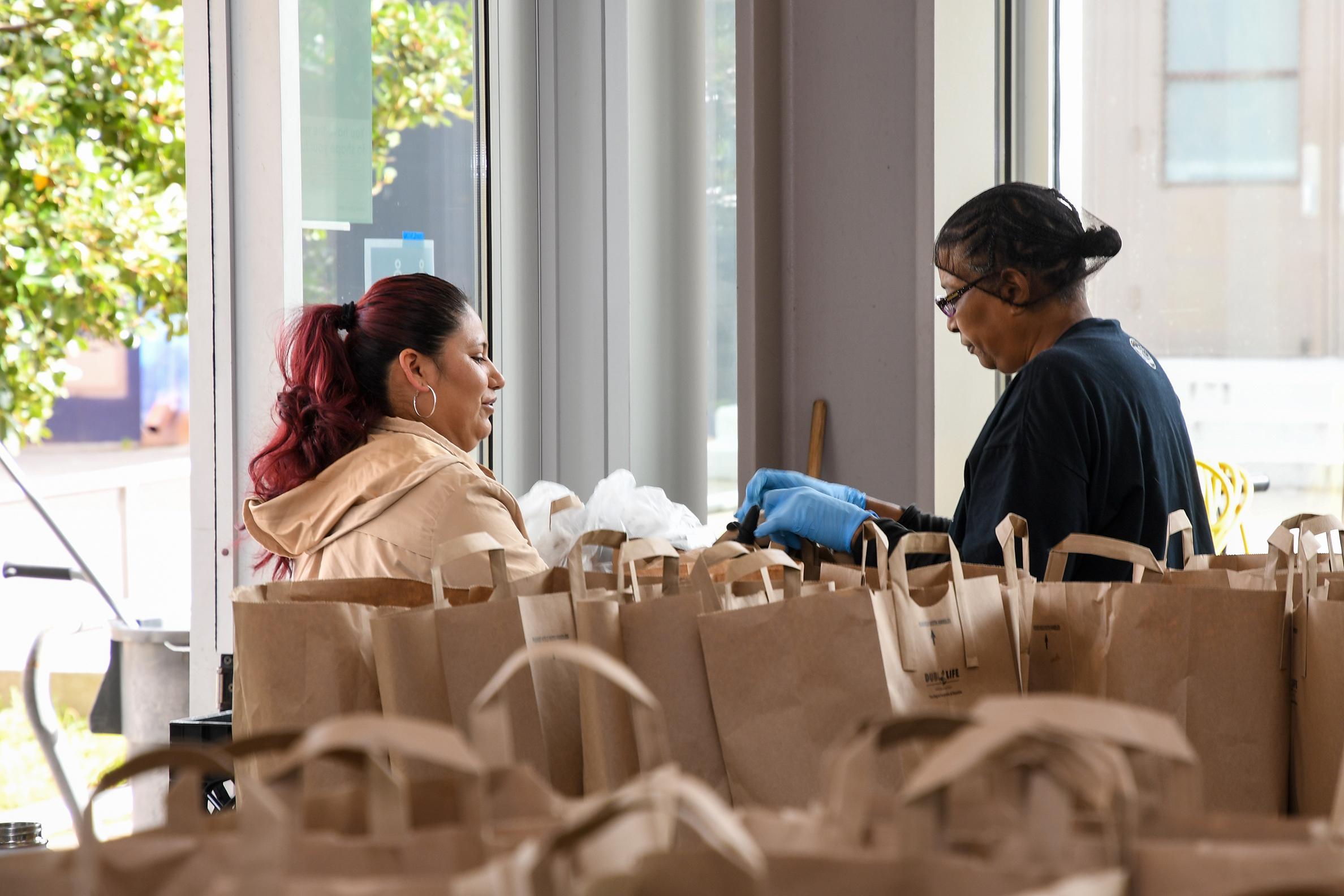 A Local 257 member (right) hands a parent a bag of food at Coliseum College Preparatory Academy in Oakland.